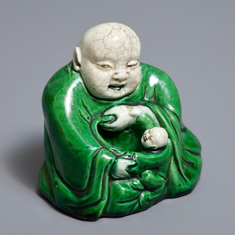 Een Chinese verte biscuit figuur van Boeddha met een kind, Kangxi