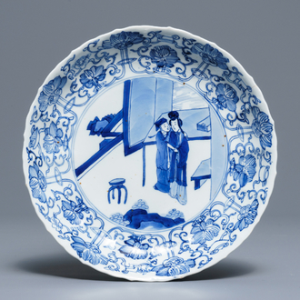 A Chinese blue and white moulded plate with an amorous couple, Kangxi mark and of the period