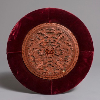 A round Chinese cinnabar lacquer plaque with two dragons, 18th C.