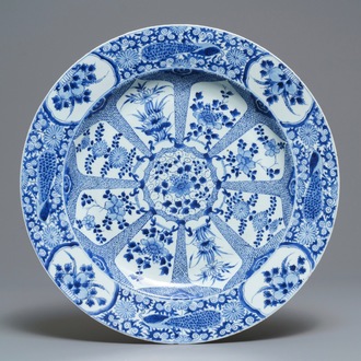 Un grand plat en porcelaine de Chine bleu et blanc à bordure aux paons, Kangxi