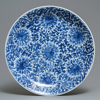 Un grand plat en porcelaine de Chine bleu et blanc à décor de rinceaux de lotus, Kangxi