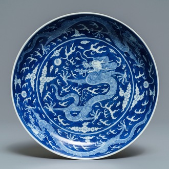 Une assiette en porcelaine de Chine bleu et blanc à décor inversé d'un dragon, marque et prob. époque de Daoguang