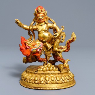 Een Sino-Tibetaanse beschilderde bronzen figuur van Jambhala op een draak, 19/20e eeuw