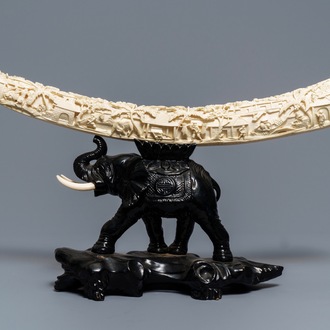 Une défense d'ivoire sculptée sur socle en bois en forme d'éléphant, Chine, vers 1900
