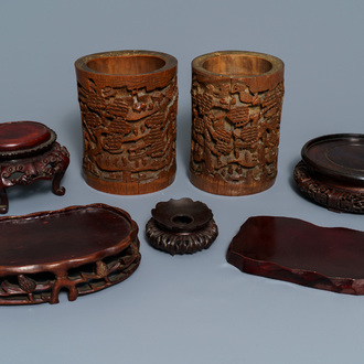 Two Chinese carved bamboo brush pots and five wooden stands, 19/20th C.