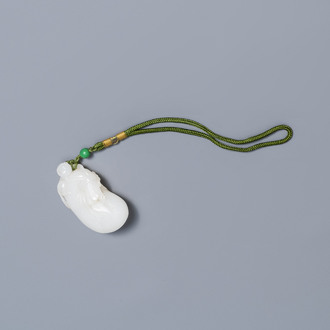 Un pendentif en jade blanc figurant un singe sur une pochette, Qing