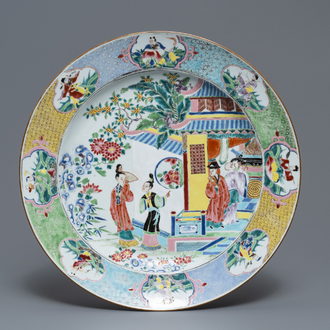 Un grand plat en porcelaine de Chine famille rose à décor de figures auprès d'un temple, Yongzheng