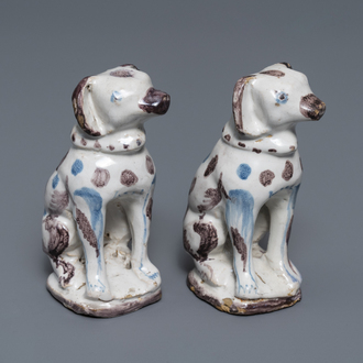 A pair of blue, white and manganese Brussels faience models of dogs, 18th C.