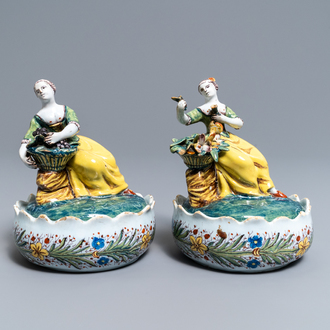A pair of polychrome Dutch Delft butter tubs with ladies selling flowers and fruits, 18th C.