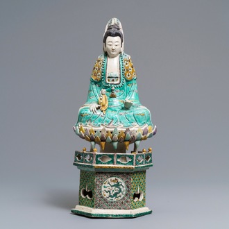 A Chinese verte biscuit group of Guanyin with child on a lotus throne, Kangxi