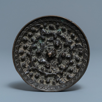 A Chinese bronze mirror with relief design, Tang