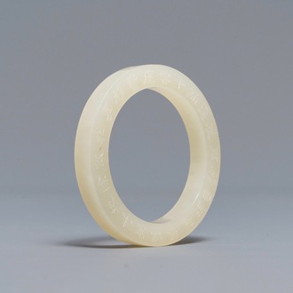 A Chinese inscribed white jade ring, 19/20th C.
