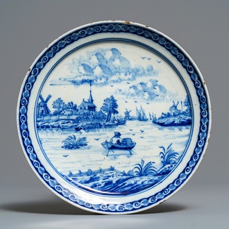 A Dutch Delft blue and white plate with a fine river landscape, 18th C.