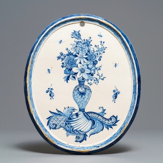 Een fijne ovale blauw-witte Delftse plaquette met gevulde bloemenvaas, 18e eeuw