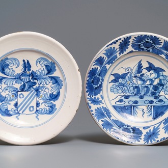 Two blue and white maiolica dishes with a fruit basket and a coat of arms, Delft or Friesland, 17/18th C.