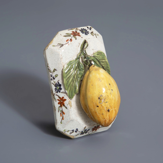 A polychrome Dutch Delft model of a lemon on a base, ca. 1800