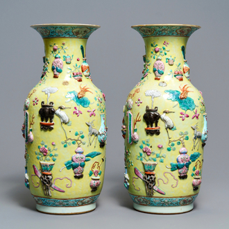 A pair of Chinese yellow-ground famille rose relief-decorated vases, 19th C.