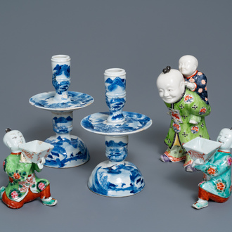 Een paar Chinese blauw-witte kandelaars en drie famille rose figuren van jongens, 19e eeuw