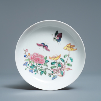 A Chinese famille rose 'ruby back' saucer dish with butterflies among flowers, Yongzheng