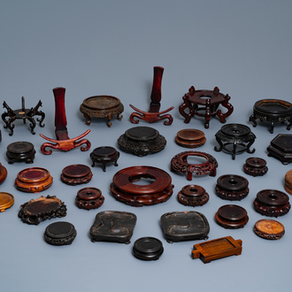 A collection of 33 Chinese carved wood stands, 19/20th C.