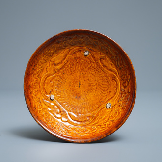 A Chinese amber-glazed relief-decorated saucer dish, Liao (916-1125)