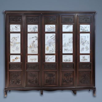 Une armoire en bois sculpté ornée de 23 plaques en porcelaine de Chine qianjiang cai, 19/20ème