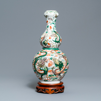 Un vase de forme double gourde en porcelaine de Chine famille verte sur socle en bois, 19/20ème