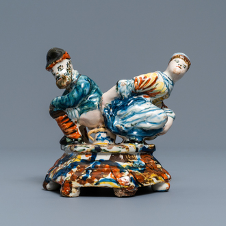 A polychrome Dutch Delft group of a man and a woman on a chamberpot, 18th C.