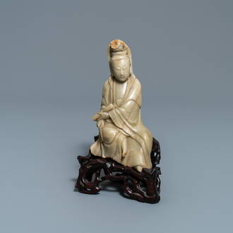 Une figure de Guanyin en pierre à savon sur socle en bois sculpté, Chine, 19ème