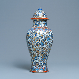 A Chinese blue and white clobbered vase and cover with floral design, Kangxi