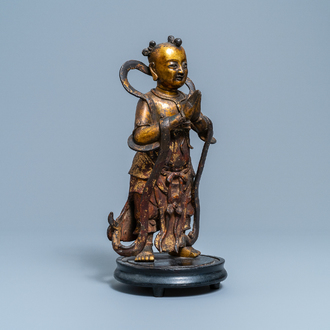 Een Chinese gelakte en vergulde bronzen figuur van een dienaar, Ming