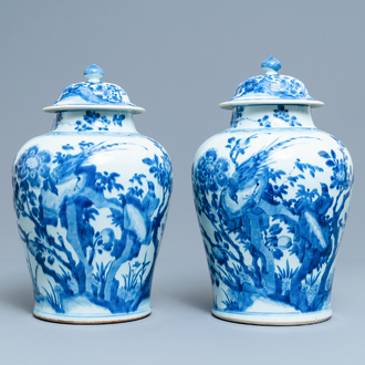 A pair of Chinese blue and white baluster vases and covers with birds in a rocky setting, Kangxi