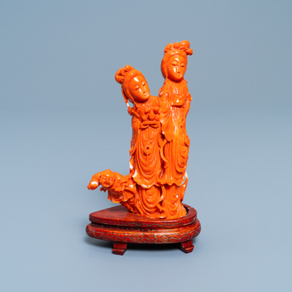 A Chinese carved red coral group of two ladies and a child, 19/20th C.