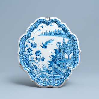Een blauw-witte Delftse chinoiserie plaquette met figuren in een pagode, 18e eeuw