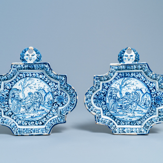 A pair of Dutch Delft blue and white plaques with mascaron suspensions, 18th C.