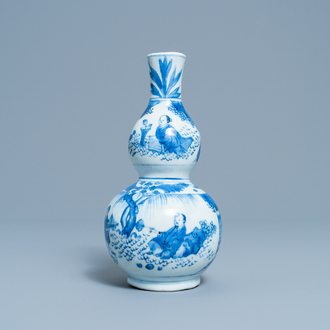 A Chinese blue and white double gourd vase with figures in a landscape, Transitional period