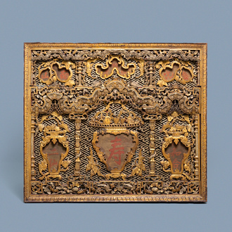 A Chinese carved and gilt wooden panel with red painted characters, 18/19th C.