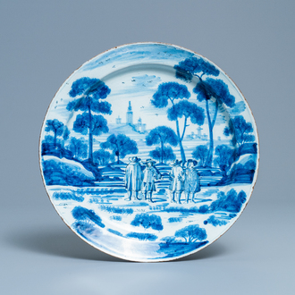 Un plat en faïence de Delft en bleu et blanc à décor de figures dans un paysage, 18ème