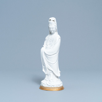 A Chinese blanc de Chine figure of Guanyin on a gilt bronze base, 18/19th C.