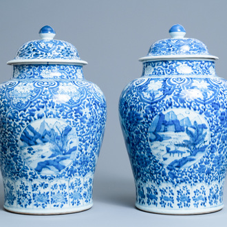 A pair of Chinese blue and white covered vases with landscape medallions on a floral ground, Kangxi