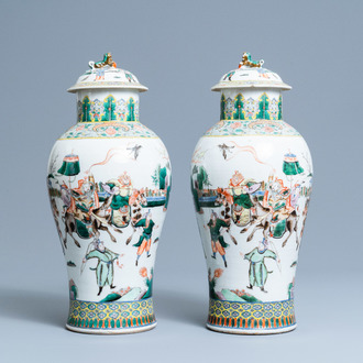 A pair of Chinese famille verte vases and covers with warrior scenes, 19th C.