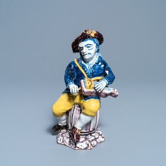 A polychrome Dutch Delft figure of a hurdy-gurdy player, 18th C.