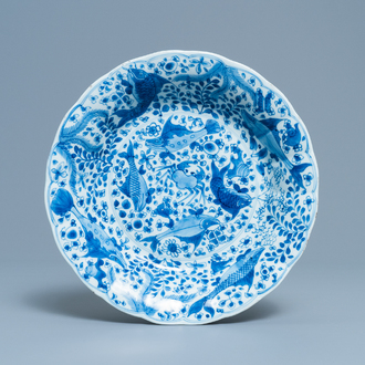 Un plat godronné en porcelaine de Chine en bleu et blanc à décor de poissons, Chine, Kangxi