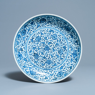 Un plat en porcelaine de Chine en bleu et blanc à décor de rinceaux floraux de style Ming, Qianlong