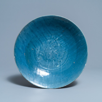Een Chinese monochrome blauwe Swatow schotel met onderglazuur decor van een karper, Ming