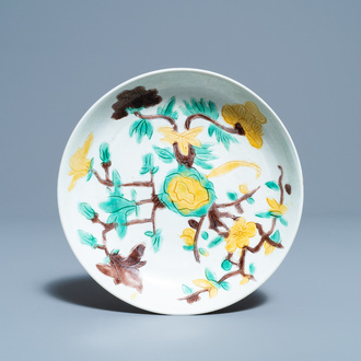 A Chinese sancai-glazed plate with carved floral design, Kangxi