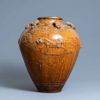 Une grande jarre de type martaban en grès émaillé brun à décor appliqué de lions bouddhistes, Ming