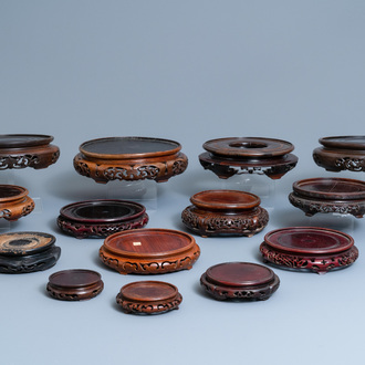 Fourteen Chinese reticulated round carved wooden stands, 19/20th C.