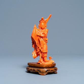 A Chinese carved red coral figure of a warrior holding a flag, 19/20th C.