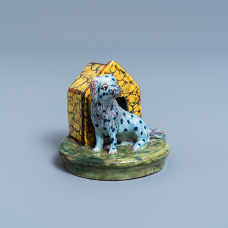 A polychrome Dutch Delft model of a dog by its doghouse, 18th C.